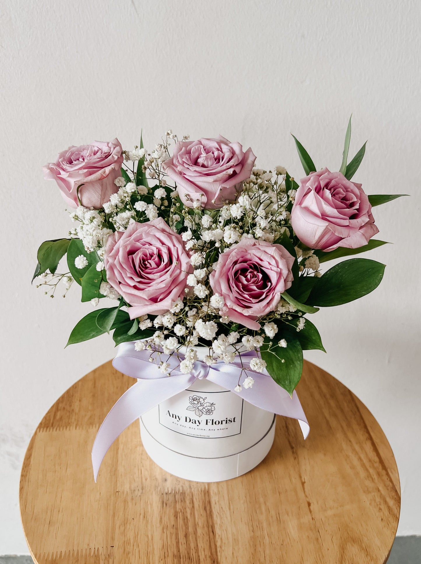 purple roses in a white bloom box