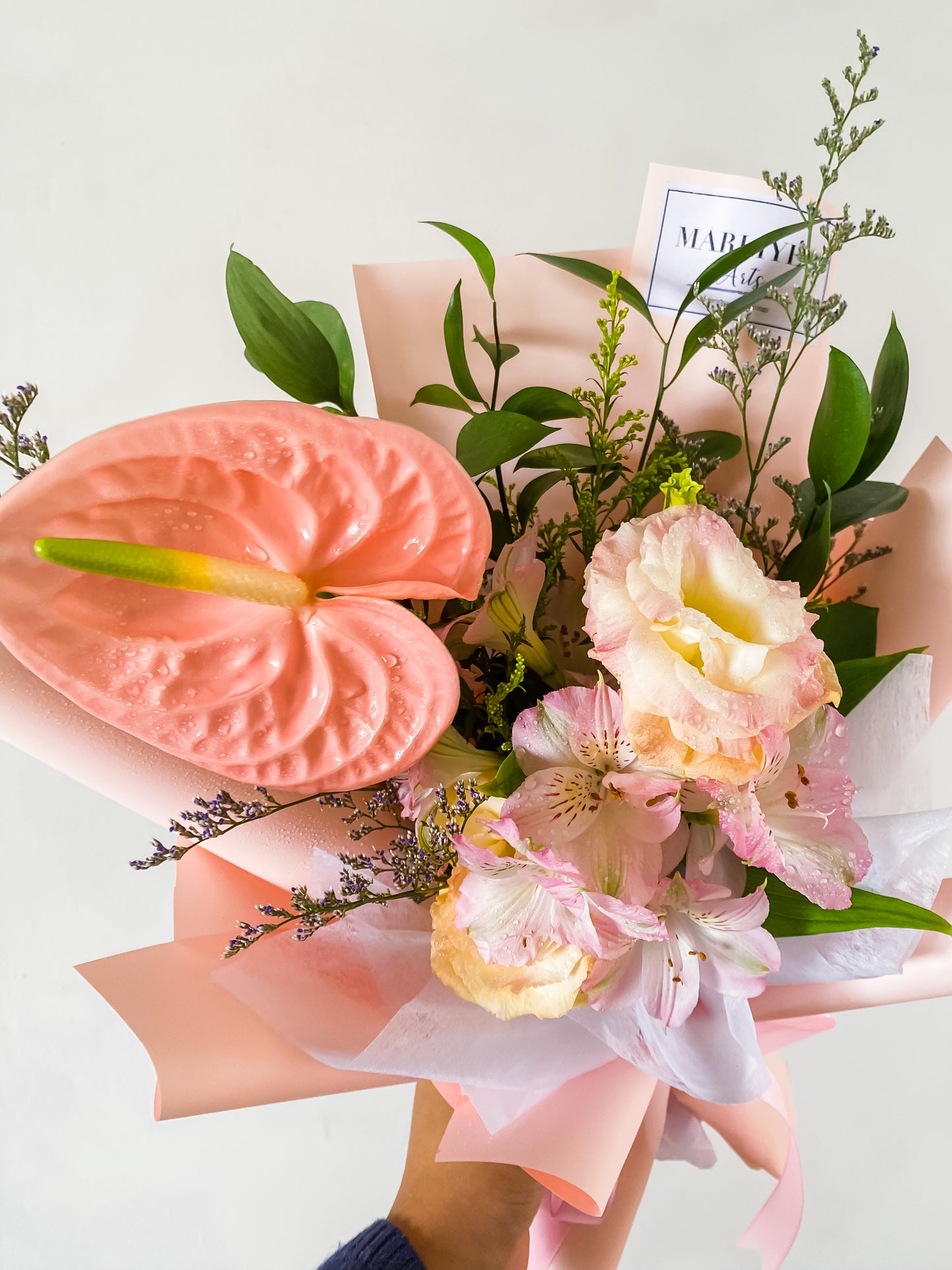 Any Day Florist​​​​​'Blushing Blue Flower Bouquet'
    A beautiful combination of Mathiollas, Abistle and assorted Fresh Kenyan Roses which symbolizes friendship and love. DefiniteBlushing Pink | Hand Bouquet of the Week
